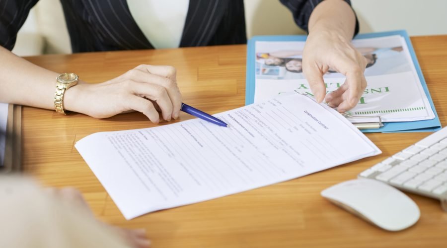 Insurance agent explaining woman what to write in contract